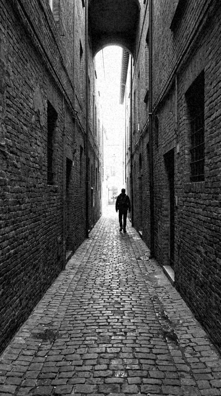 Graded with Film and Darkroom: The alley on a working print. Firm blacks, clarity up, the grain left in.